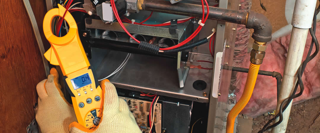 hvac tech repairing furnace
